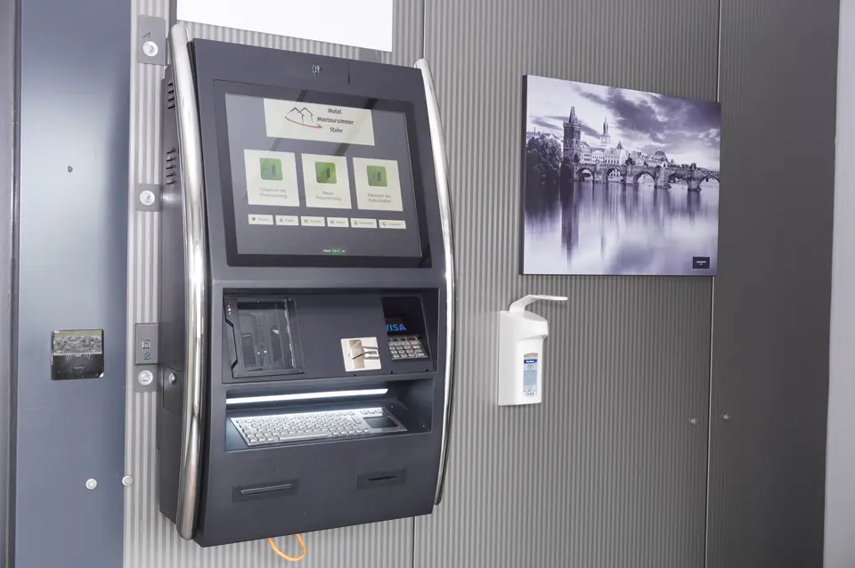 Self check-in kiosk with screen and card reader in the entrance area