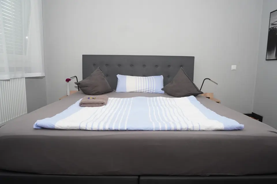 Double room with box-spring bed and blue and white bed linen