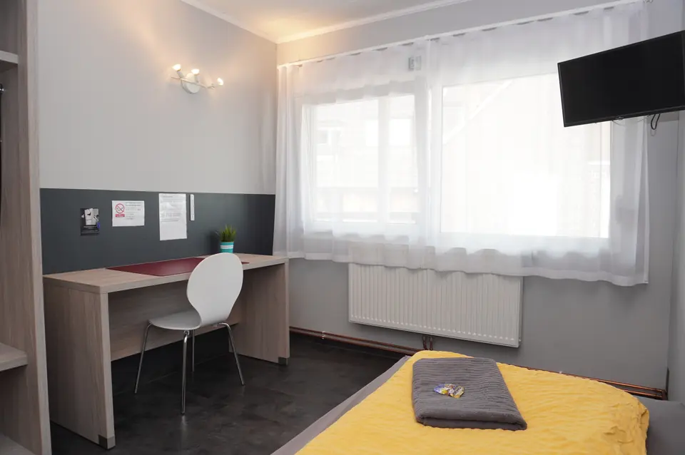 Single room with desk, chair and TV